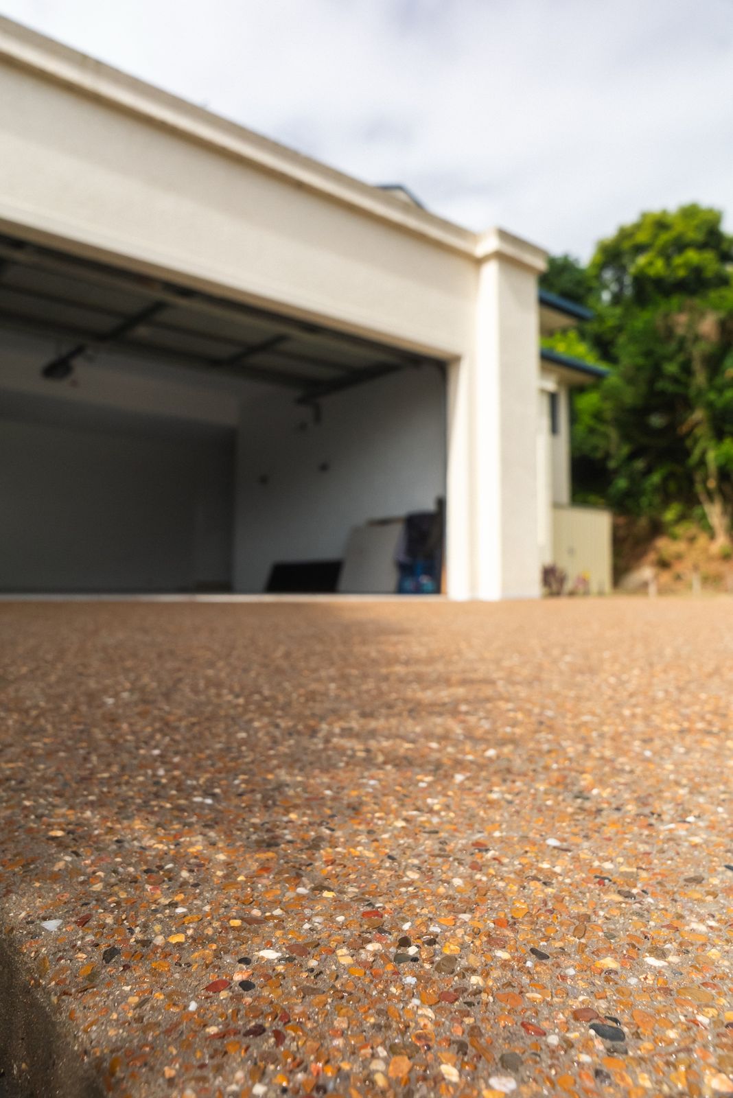 Close-up of an exposed aggregate driveway leading to a garage